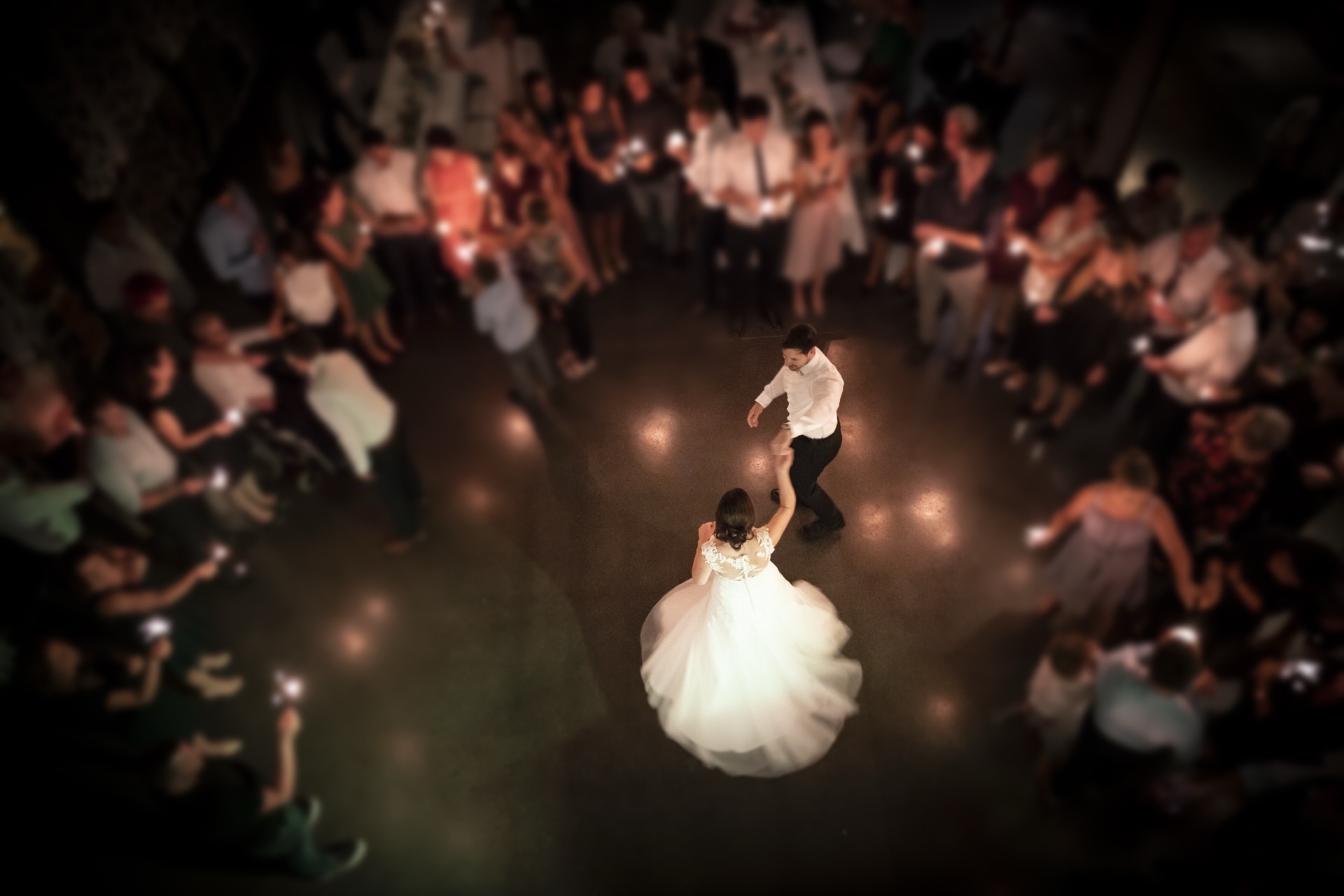 A couple sharing their first dance with guests gathered around